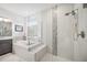 Bright bathroom featuring a soaking tub, glass shower, and modern fixtures at 10179 Milky Way Cir, Sarasota, FL 34241