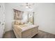 This is a cozy bedroom featuring light wood floors, a ceiling fan, and a queen-size bed with decorative pillows at 10179 Milky Way Cir, Sarasota, FL 34241