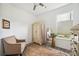 Bright bedroom with ceiling fan, chair, rug, window and antique white armoire and dresser at 10179 Milky Way Cir, Sarasota, FL 34241