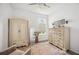 A staged bedroom with hardwood floors, an area rug, an armoire, and a dresser at 10179 Milky Way Cir, Sarasota, FL 34241