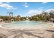 A large, lagoon-style community pool, surrounded by palm trees and seating areas at 10179 Milky Way Cir, Sarasota, FL 34241