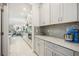 Butler's pantry with gray cabinets, decorative backsplash, and sleek appliances, perfect for entertaining at 10179 Milky Way Cir, Sarasota, FL 34241