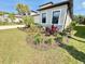 Landscaped front yard featuring colorful flowers and tropical plants around the facade of the home at 10179 Milky Way Cir, Sarasota, FL 34241