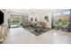 Spacious living room with tile floors, modern furniture, and sliding glass doors to the pool area at 10179 Milky Way Cir, Sarasota, FL 34241