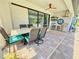 Covered patio with outdoor kitchen, grill, bar area, television, and comfortable dining set at 10179 Milky Way Cir, Sarasota, FL 34241