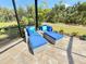 Screened lanai with woven chaise lounges and plush blue cushions overlooking a beautiful yard at 10179 Milky Way Cir, Sarasota, FL 34241