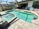 A private screened-in pool with pavers, a hot tub, and ample seating at 10179 Milky Way Cir, Sarasota, FL 34241