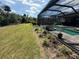 Relaxing screened-in pool and spa area with a well-manicured lawn and mature landscaping at 10179 Milky Way Cir, Sarasota, FL 34241