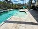 A private screened-in pool with a hot tub and a waterfall feature at 10179 Milky Way Cir, Sarasota, FL 34241