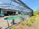 Beautiful screened-in pool and spa area with comfortable outdoor seating and lush landscaping at 10179 Milky Way Cir, Sarasota, FL 34241