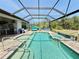 Beautiful outdoor pool and hot tub with an outdoor kitchen area and screened-in enclosure at 10179 Milky Way Cir, Sarasota, FL 34241