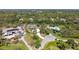 Expansive aerial view showcasing the home nestled within a lush, green landscape with surrounding trees and circular driveway at 1030 Bahia Vista Ct, Sarasota, FL 34232