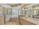 Bright bathroom with tiled floors, a luxurious tub surrounded by glass brick, and spacious vanity at 1030 Bahia Vista Ct, Sarasota, FL 34232