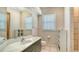 Clean bathroom with light tile flooring, a large mirror, a gray vanity, and built-in shelving at 1030 Bahia Vista Ct, Sarasota, FL 34232