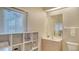 Bright bathroom featuring storage shelving, a window with blinds, and a neutral color scheme at 1030 Bahia Vista Ct, Sarasota, FL 34232