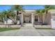 Welcoming home entrance with double doors, decorative pillars, and tropical landscaping for curb appeal at 1030 Bahia Vista Ct, Sarasota, FL 34232