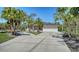 Inviting home exterior with a spacious driveway, manicured lawn, and palm trees for added curb appeal at 1030 Bahia Vista Ct, Sarasota, FL 34232