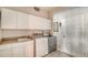 Functional laundry room with tile floor, washer, dryer, sink, and ample storage cabinets at 1030 Bahia Vista Ct, Sarasota, FL 34232