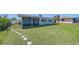 The backyard features a lush lawn and a charming screened-in porch, perfect for enjoying the outdoors at 108 Peckham Sw St, Port Charlotte, FL 33952