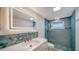 Updated bathroom with an illuminated mirror and a tiled shower at 108 Peckham Sw St, Port Charlotte, FL 33952