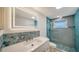 Updated bathroom with an illuminated mirror and a tiled shower at 108 Peckham Sw St, Port Charlotte, FL 33952