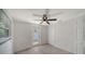Well-lit bedroom featuring neutral paint, a ceiling fan, and a door to the outside at 108 Peckham Sw St, Port Charlotte, FL 33952