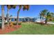 Beautiful single-Gathering home with lush landscaping, palm trees, and a freshly painted exterior at 108 Peckham Sw St, Port Charlotte, FL 33952