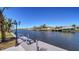 Scenic waterfront view from the dock, featuring palm trees and clear skies at 108 Peckham Sw St, Port Charlotte, FL 33952