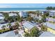 Stunning aerial view showcases a vibrant beach community with palm trees and the ocean in the background at 110 Oak Ave # A, Anna Maria, FL 34216