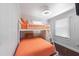 Cozy bedroom featuring white bunk beds with orange covers and white paneled walls at 110 Oak Ave # A, Anna Maria, FL 34216