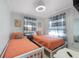 Charming bedroom with two twin beds, coastal decor, and plenty of natural light from the two windows at 110 Oak Ave # A, Anna Maria, FL 34216