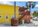 Charming yellow home featuring a staircase leading to a covered wooden deck with a pergola at 110 Oak Ave # A, Anna Maria, FL 34216