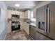 Modern kitchen with stainless steel appliances, white cabinetry, and sleek countertops at 110 Oak Ave # A, Anna Maria, FL 34216