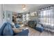 Bright and airy living room with a blue sofa, striped curtains, and open concept to the kitchen at 110 Oak Ave # A, Anna Maria, FL 34216