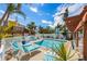 Beautiful pool area with lounge chairs, lush landscaping, and a charming yellow house in the background at 110 Oak Ave # A, Anna Maria, FL 34216