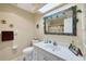 Well-lit bathroom features a toilet, mirror, vanity, sink, and shower at 115 65Th Street Nw Ct, Bradenton, FL 34209