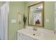 Bathroom featuring a white vanity, gold mirror and pastel green walls at 115 65Th Street Nw Ct, Bradenton, FL 34209