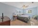 Bright bedroom with light blue walls, ceiling fan and two large windows at 115 65Th Street Nw Ct, Bradenton, FL 34209