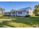 Exterior view of a single-story home with a metal roof, and landscaped yard at 115 65Th Street Nw Ct, Bradenton, FL 34209