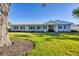 Well-maintained single-story house with a metal roof, lawn, and classic facade at 115 65Th Street Nw Ct, Bradenton, FL 34209