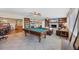 Spacious living room with fireplace, billiard table and built-in bookshelves at 115 65Th Street Nw Ct, Bradenton, FL 34209