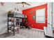Bedroom with bright red walls, a loft bed with workspace, and a ceiling fan at 11659 Little River Way, Parrish, FL 34219