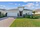 Charming single-story home featuring brick driveway and manicured lawn at 11659 Little River Way, Parrish, FL 34219