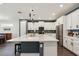 Modern kitchen boasts white cabinets, central island, and modern lighting at 11659 Little River Way, Parrish, FL 34219