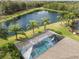 Aerial view of the pool and backyard with lush landscaping overlooking the pond, providing a peaceful retreat at 11742 Forest Park Cir, Bradenton, FL 34211