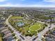 An aerial view of a community park shows well-manicured green spaces, tennis courts, a splash pad and playground equipment at 11742 Forest Park Cir, Bradenton, FL 34211