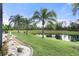 Lush backyard with a serene pond view and mature palm trees creating a private oasis at 11742 Forest Park Cir, Bradenton, FL 34211