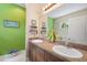 Bathroom with double sinks, granite countertops, and a bright green wall at 11742 Forest Park Cir, Bradenton, FL 34211