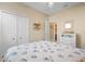 Bright bedroom with seashell-themed bedding, white dresser, and closet, offering a tranquil and organized space at 11742 Forest Park Cir, Bradenton, FL 34211