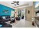 Bright living room with a glass sliding door to the outside patio, coastal decor, and tile flooring at 11742 Forest Park Cir, Bradenton, FL 34211